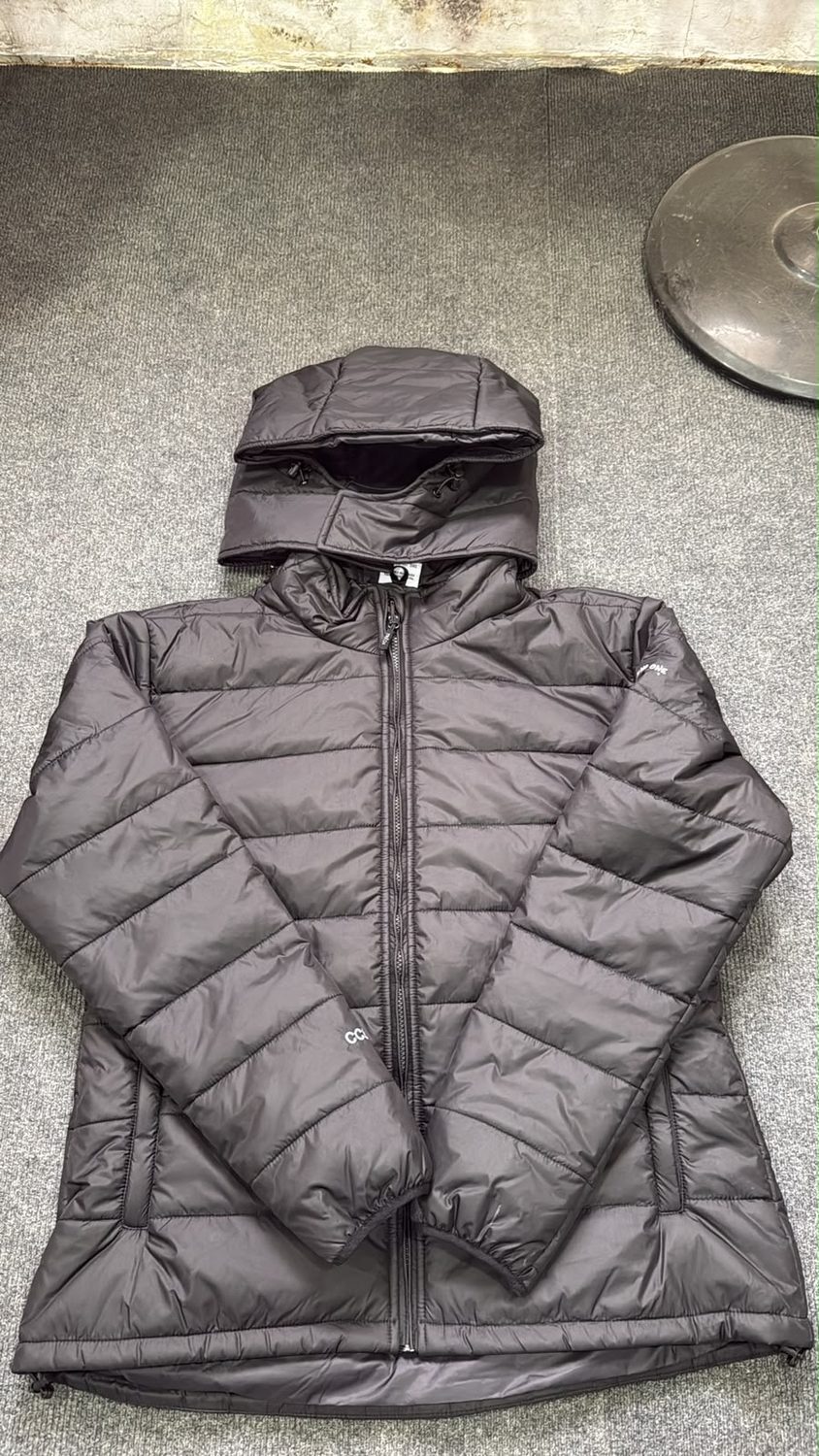 A charcoal quilted puffer jacket with a hood, laid flat and zipped